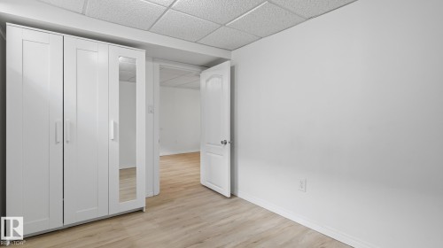 Light wood-finish flooring with white walls and trim - 11836 62 Street Nw, Edmonton, AB 
