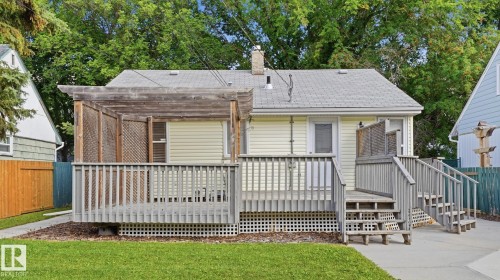 Rear deck with a wood pergola, lattice skirting, and dual stair access - 11836 62 Street Nw, Edmonton, AB 