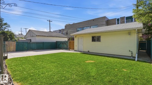 Expansive green lawn, concrete patio, privacy fencing, detached structure with siding, and an access door - 11836 62 Street Nw, Edmonton, AB 