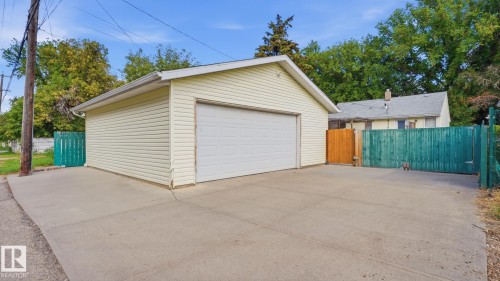 Detached garage featuring horizontal siding and a white overhead door - 11836 62 Street Nw, Edmonton, AB 