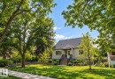 Stucco exterior with a dark shingle roof and a front awning - 6542 112A Street Nw, Edmonton, AB 