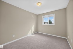 Neutral wall tones with a single window, carpeted flooring, and a ceiling-mounted light fixture - 
