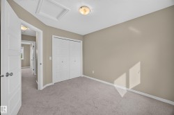 Neutral tone wall paint, light gray carpeting, white bi-fold closet doors, white trim, and a flush mount ceiling light - 
