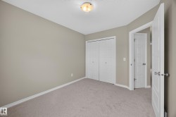 Spacious bedroom with neutral carpeting, dual closets with white bi-fold doors, recessed ceiling lighting, and pristine white trim throughout - 