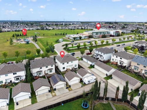 Aerial perspective of a residential neighborhood with detached homes, green spaces, and community buildings - 483 Watt Boulevard Sw, Edmonton, AB 