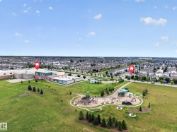 Expansive green space featuring a playground, manicured lawn, and mature trees - 
