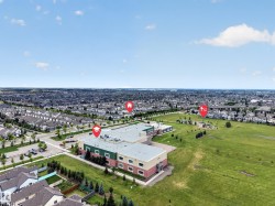 Expansive aerial perspective showcasing a substantial community with abundant green spaces and a large institutional building - 