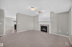 Neutral wall paint, fireplace with a decorative mantel, tiled hearth, recessed lighting, and carpeted flooring - 