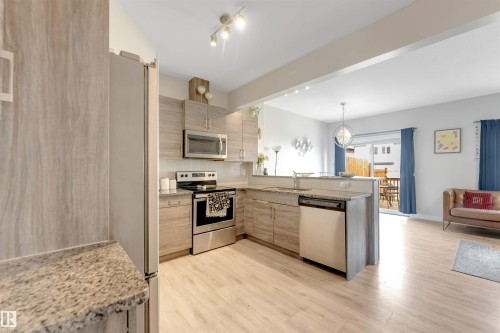Contemporary kitchen featuring light wood-finish cabinetry, granite-style countertops, and stainless steel appliances - 2004 15 Avenue Nw, Edmonton, AB 