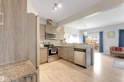 Contemporary kitchen featuring light wood-finish cabinetry, granite-style countertops, and stainless steel appliances - 