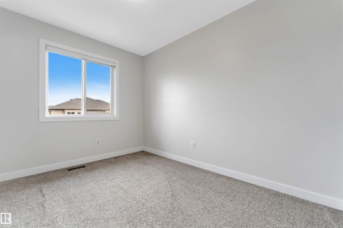 Spacious room featuring light gray walls, white trim, and gray carpet - 2004 15 Avenue Nw, Edmonton, AB 
