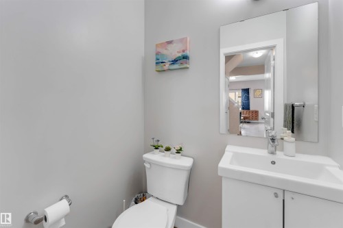 Recessed lighting illuminating a bathroom vanity with integrated sink, chrome faucet, and mirrored medicine cabinet - 2004 15 Avenue Nw, Edmonton, AB 