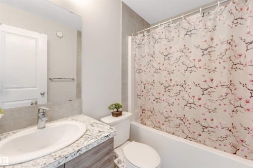 Vanity with integrated sink, stone-finish countertop, and chrome faucet - 2004 15 Avenue Nw, Edmonton, AB 