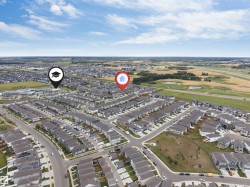 Aerial perspective of a developed residential neighborhood with nearby green spaces and a commercial area - 