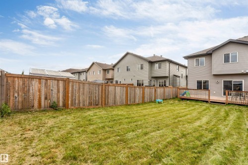 Expansive grassy yard with a full privacy fence and a wood-finish deck featuring a wood-finish railing - 2004 15 Avenue Nw, Edmonton, AB 