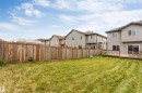 Expansive grassy yard with a full privacy fence and a wood-finish deck featuring a wood-finish railing - 2004 15 Avenue Nw, Edmonton, AB 