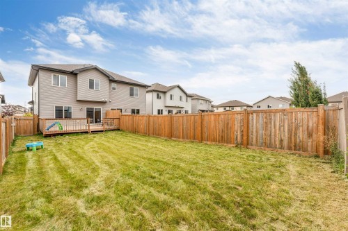 Expansive fenced backyard with a wood deck and sliding glass door access - 2004 15 Avenue Nw, Edmonton, AB 