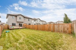 Expansive fenced backyard with a wood deck and sliding glass door access - 