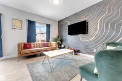 Accent wall with curvilinear pattern, wood-finish flooring, and white trim - 