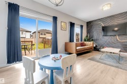 Wood-finish flooring, accent wall with a geometric pattern, ceiling-mounted light fixture, sliding glass doors, and an exterior wood deck - 
