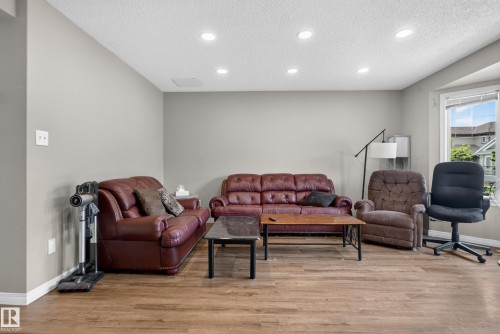 Recessed ceiling lighting illuminates the room with wood-finish flooring and light-colored walls - 7817 Schmid Place Nw, Edmonton, AB 