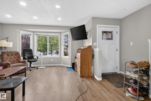 Recessed lighting, wood-finish flooring, bay window, white paneled door, and neutral wall paint - 7817 Schmid Place Nw, Edmonton, AB 