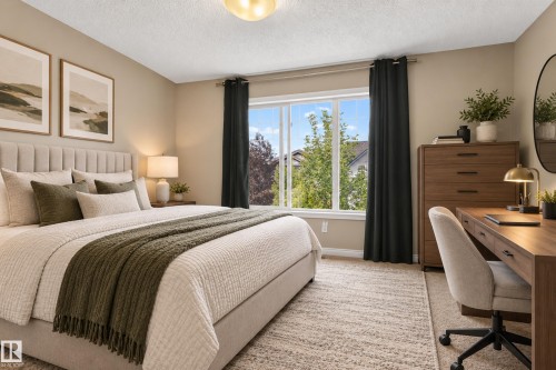 Neutral tone walls, upholstered bed frame, large window with natural light, wood-finish desk, and a textured area rug - 7817 Schmid Place Nw, Edmonton, AB 
