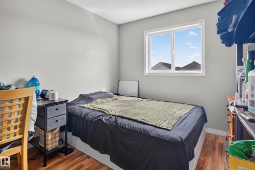 Hardwood-finish flooring, white trim, and a window with white casing - 7817 Schmid Place Nw, Edmonton, AB 