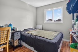 Hardwood-finish flooring, white trim, and a window with white casing - 