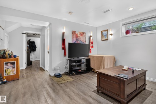Wood-finish flooring throughout, recessed ceiling lighting, and a white trim window - 7817 Schmid Place Nw, Edmonton, AB 