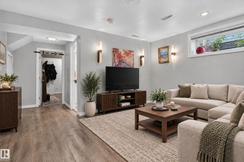 Recessed lighting, light gray wall finishes, wood-finish flooring, and a window well with natural light - 7817 Schmid Place Nw, Edmonton, AB 