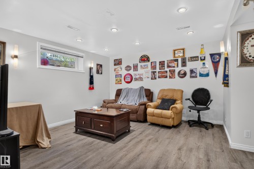Recessed lighting, wood-finish flooring, white baseboards, and a window for natural light - 7817 Schmid Place Nw, Edmonton, AB 