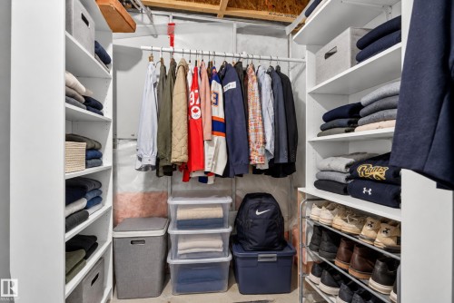 Built-in closet organization system featuring white shelving units, hanging clothes rods, and a multi-level shoe rack - 7817 Schmid Place Nw, Edmonton, AB 