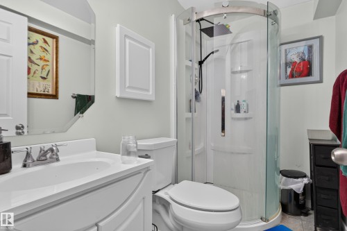 White vanity with integrated sink, chrome faucet, and mirrored cabinet - 7817 Schmid Place Nw, Edmonton, AB 