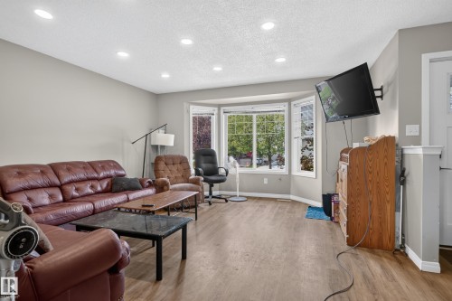 Recessed ceiling lighting, wood-finish flooring, and a bay window - 7817 Schmid Place Nw, Edmonton, AB 