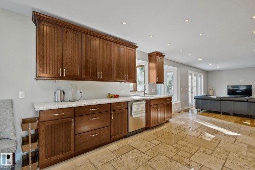 Extensive wood cabinetry, light-toned countertops, integrated stainless steel dishwasher, recessed lighting, and tile flooring - 12403 29A Avenue Nw, Edmonton, AB 