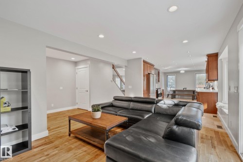 Open-concept living space featuring wood-finish flooring, recessed lighting, and a staircase with wood treads and a metal railing - 12403 29A Avenue Nw, Edmonton, AB 