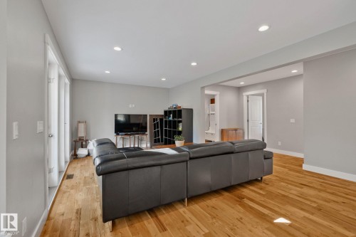 Open-concept living space featuring wood-finish flooring, recessed lighting, and large window panels - 12403 29A Avenue Nw, Edmonton, AB 