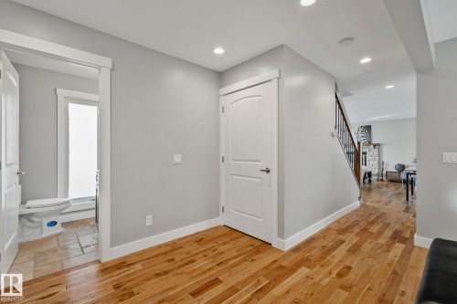 Wood-finish flooring, recessed lighting, and a staircase with an iron spindle railing - 12403 29A Avenue Nw, Edmonton, AB 