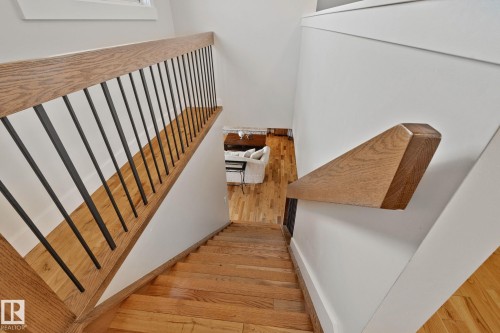 Hardwood flooring, wood handrails, and black metal balusters - 12403 29A Avenue Nw, Edmonton, AB 