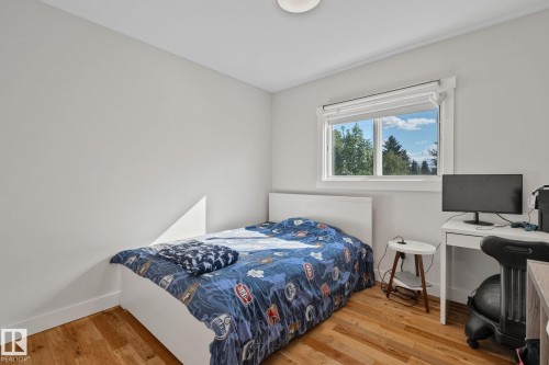 Hardwood flooring, painted walls, window with trim, and a ceiling light fixture - 12403 29A Avenue Nw, Edmonton, AB 