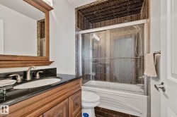 Wood-finish vanity with an undermount sink, black countertop, and brushed nickel faucet - 