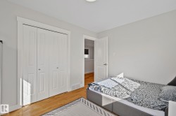 Light gray walls, light wood-finish flooring, white bi-fold closet doors, white trim, and a flush-mount ceiling light - 