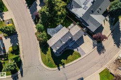 Property situated on a curved street with mature trees and a paved driveway - 