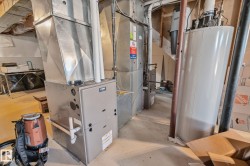 York furnace with metal ductwork, water heater, and exposed overhead joists - 