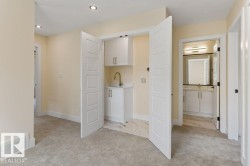 Spacious primary suite featuring a dedicated walk-in closet with double doors, dual vanity bathroom with framed mirror and brushed nickel hardware, neutral wall finishes, and recessed ceiling lighting - 