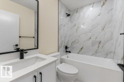 4th Bathroom - 4 Piece - Modern bathroom featuring a white vanity with a quartz countertop, matte black fixtures, a rectangular undermount sink, and a framed mirror - 