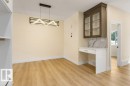 Bright, open dining area showcasing warm wood-finish flooring, recessed lighting, and a geometric pendant fixture - 10323 79 Street Nw, Edmonton, AB 