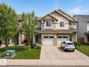 Siding exterior with stone accents, two-car garage, concrete driveway, and front lawn - 1668 Chapman Way Sw, Edmonton, AB 