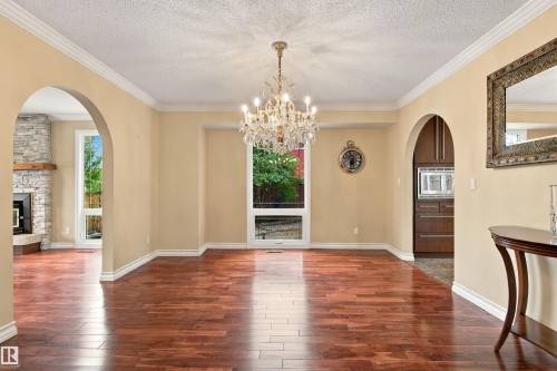 Hardwood-finish flooring, arched doorways, crown molding, and a crystal chandelier - 14103 60 Avenue Nw, Edmonton, AB 
